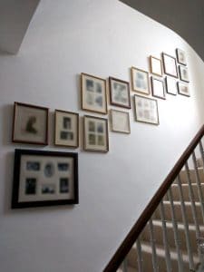 A sepia collage wall running up the staircase in a home in Richmond.